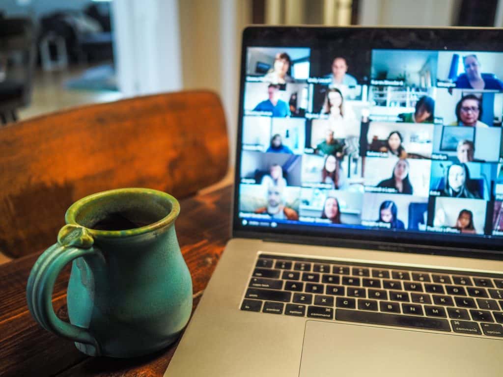 laptop open with a grid-view of people having an online meeting