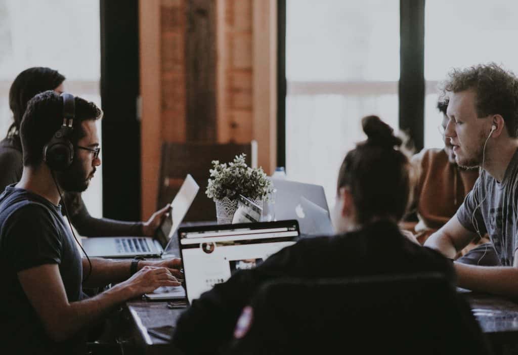 Group of people problem solving on laptops