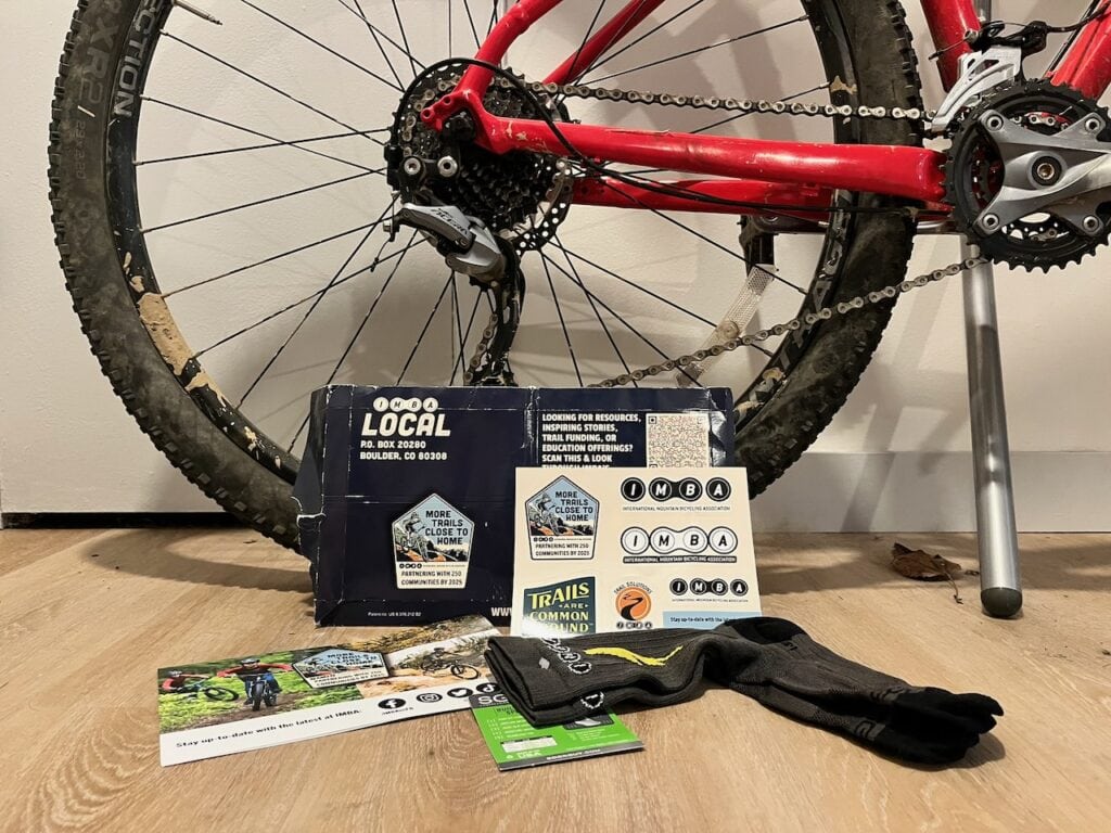 Mountain bike with gear and accessories on a wooden floor.